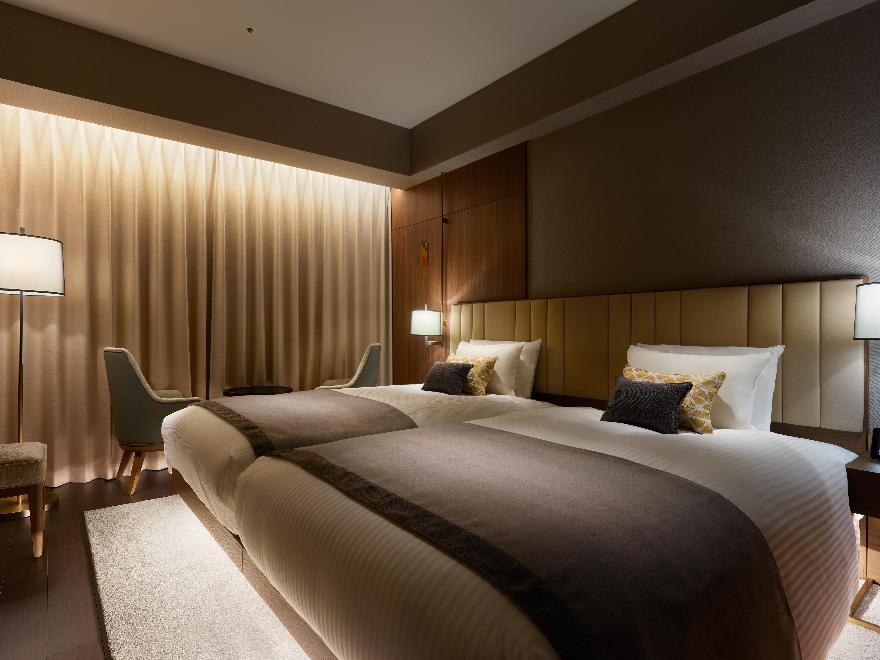 Mitsui Garden Hotel Roppongi Tokyo Premier Екстериор снимка The photo shows a modern hotel room featuring two twin beds with elegant bedding. The room is adorned with soft, neutral tones and has a warm ambiance created by subtle lighting. A pair of bedside lamps provide additional light, and there is a cozy c