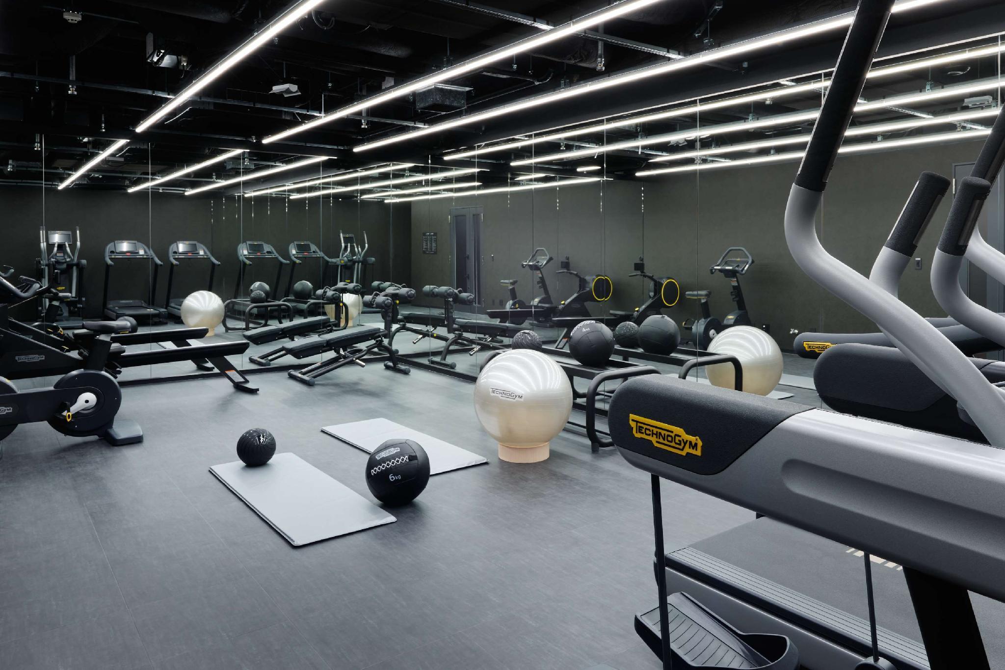 Mitsui Garden Hotel Roppongi Tokyo Premier Екстериор снимка The photo shows a modern gym interior. The space features various exercise equipment, including cardio machines like treadmills and elliptical trainers, weight machines, and free weights. There are also exercise mats and fitness balls scattered throu